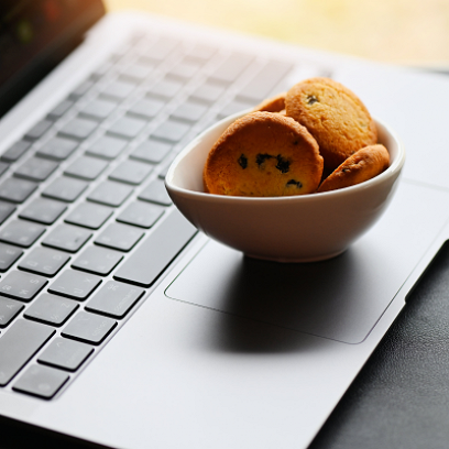 En bolle med informasjonskapsler på en bærbar PC – en subtil påminnelse om viktigheten av å forstå nettsiders informasjonskapselpolicy.