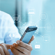 En person holder en smarttelefon med ikoner som representerer nettjenester som shopping, meldinger og nettlesing, rundt enheten.
