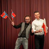Menn med polske og norske flagg sitter vendt mot hverandre for å understreke den interkulturelle dialogen.